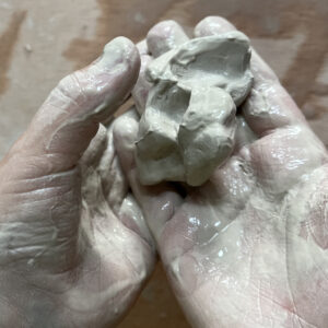 Deux mains d'enfant remplies d'argile, prêtes à créer de magnifiques œuvres d'art dans notre atelier céramique pour enfants et adultes.