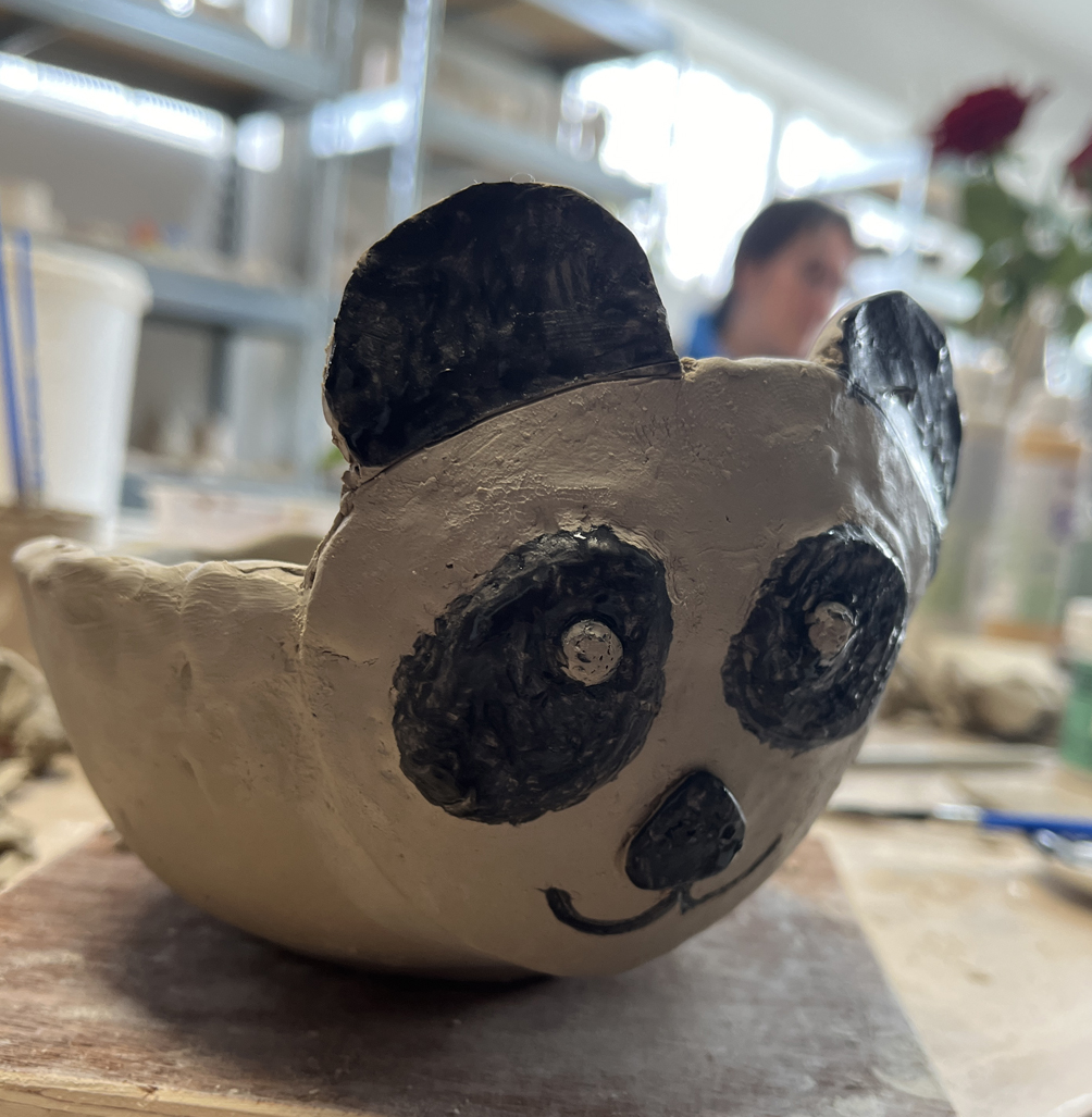 un bol façonné à la main par un enfant dans notre atelier de céramique, personnalisé avec une tête de panda. trop mignon !