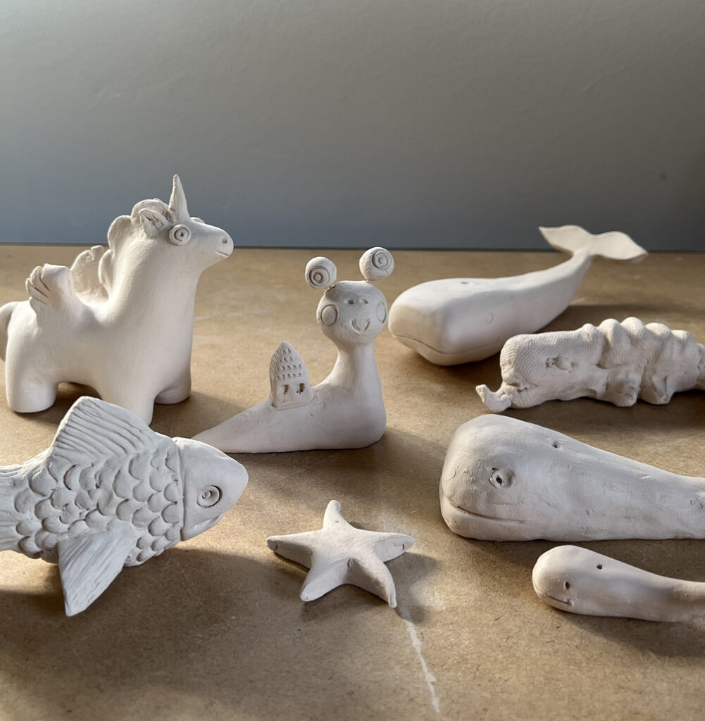 Des petites créatures en terre cuite modelés par les enfants dans un atelier de céramique à Sars-et-Rosières