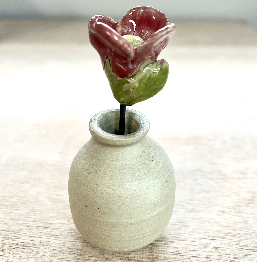 un mini vase en céramique avec une petite fleur en céramique