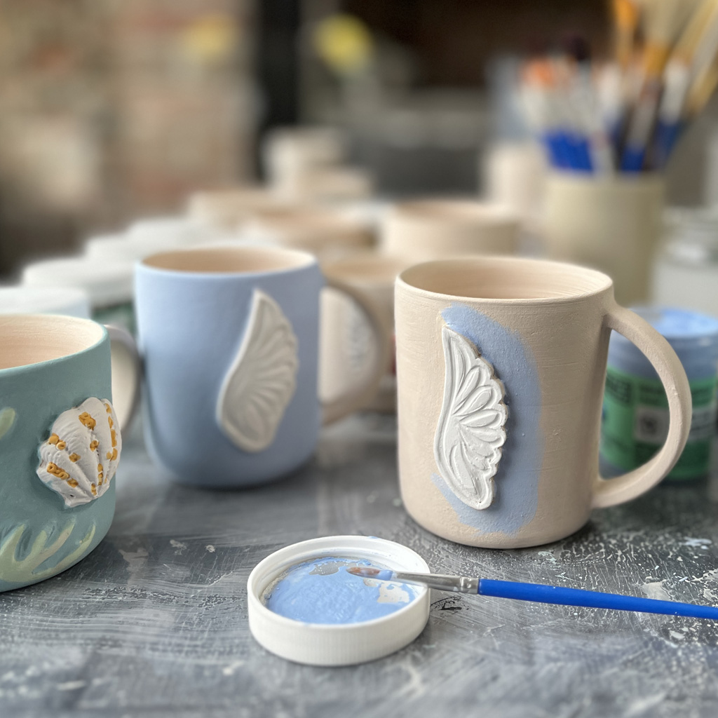 un mug en céramique pendant la décoration avec les engobes